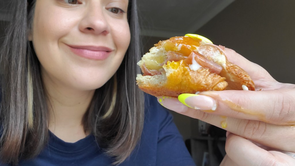 Woman eating a keto-friendly eggs benedict sandwich