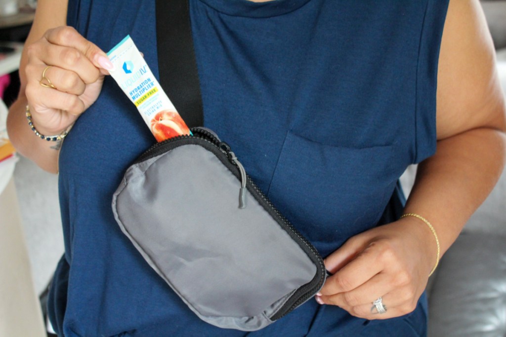 Woman pulling a sugar free liquid IV pack out of her crossbody bag
