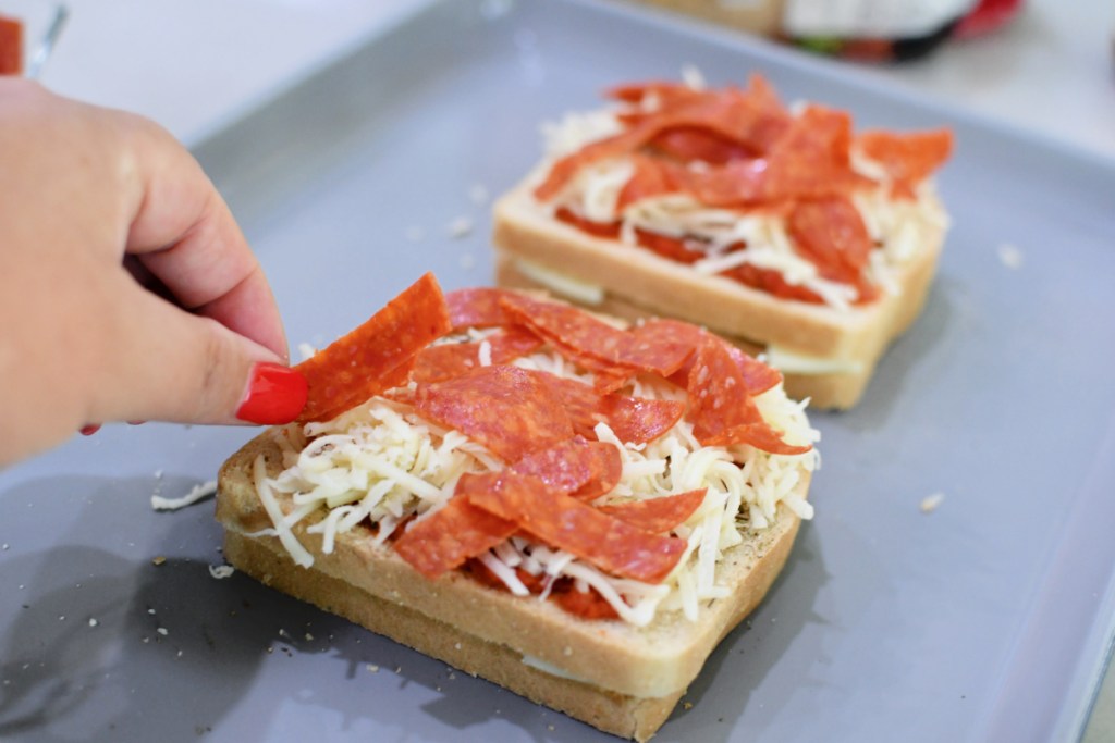 adding pepperoni to toast