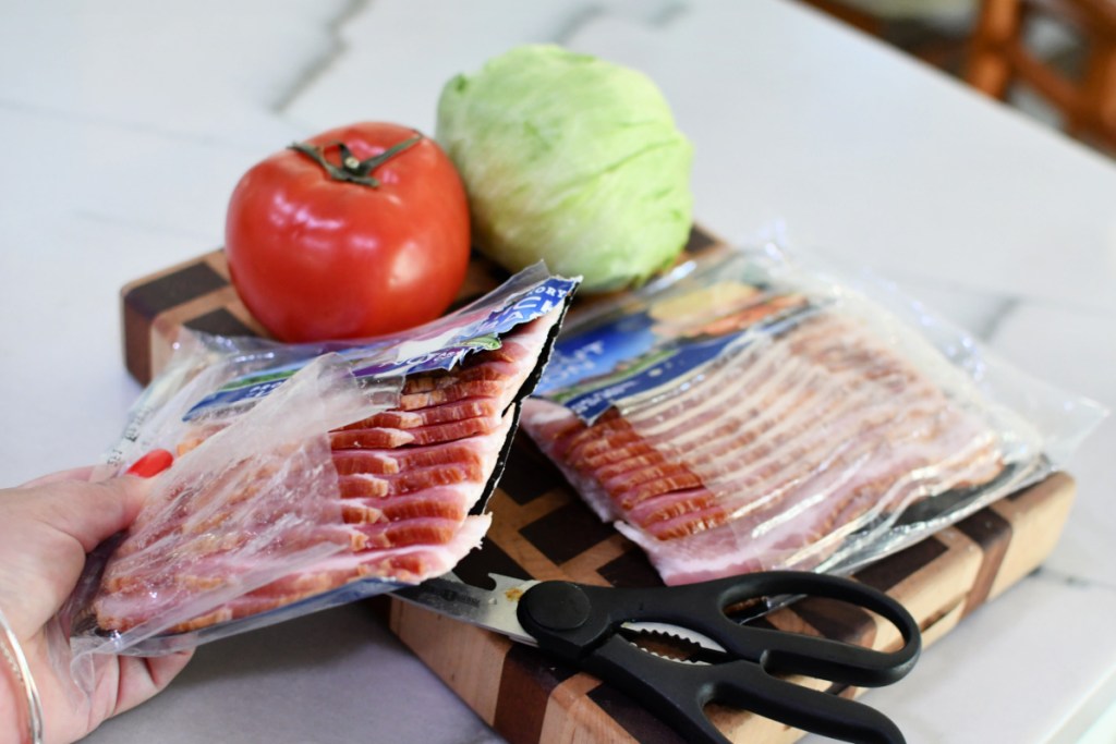 cutting a package of bacon in half to make a keto BLT 