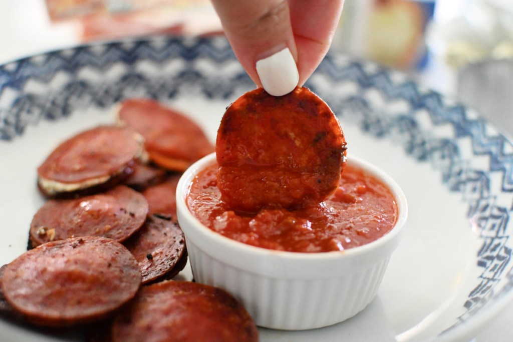 dipping pepperoni bites into marinara