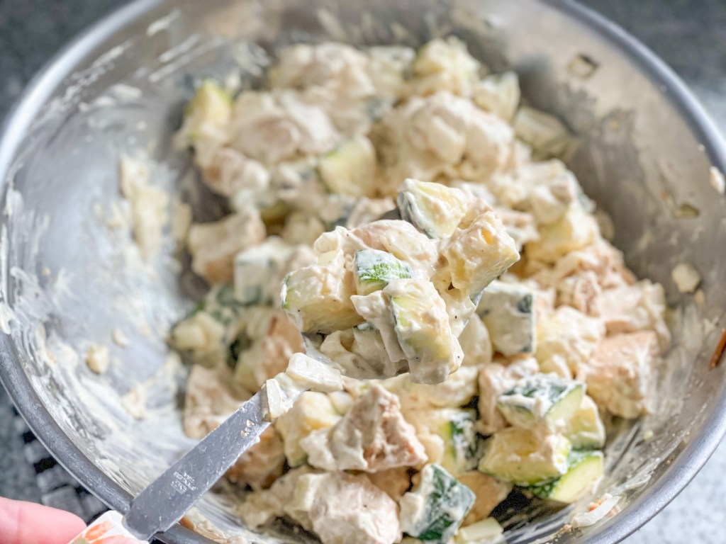 bowl with chopped chicken, zucchini, and onion mixed with a cream sauce