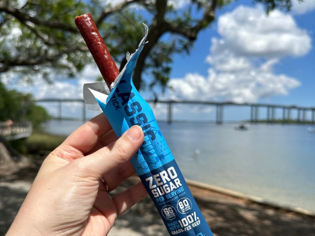 holding an unwrapped beef stick