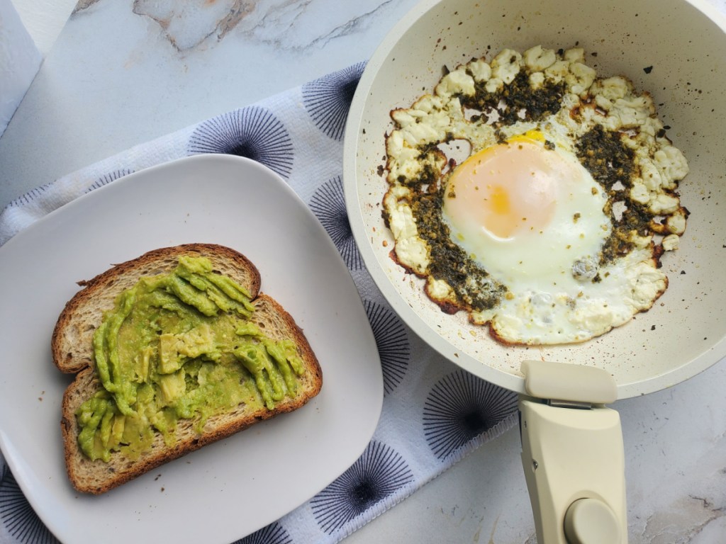 Making a keto breakfast of pesto eggs on avocado toast