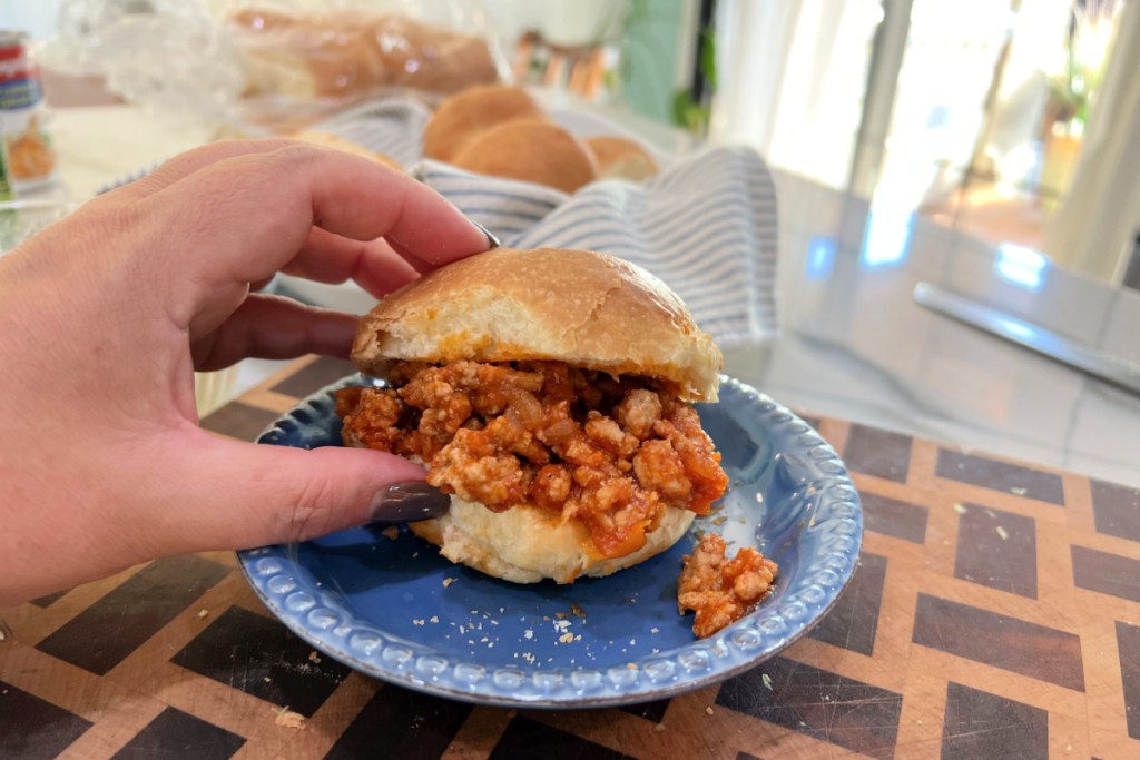 holding a sloppy joe slider on hero keto roll