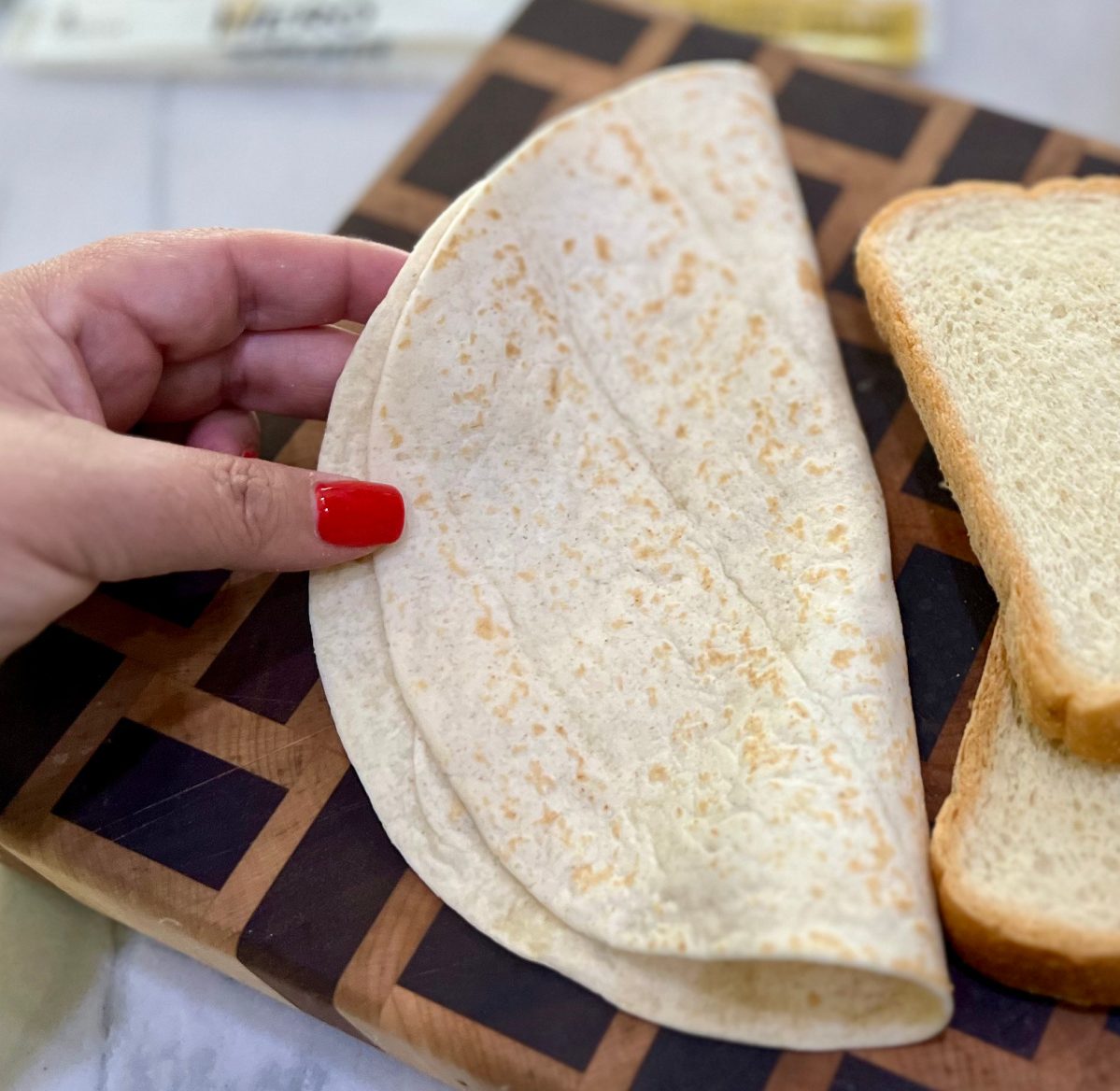 Hand holding a zero carb tortilla from hero bread