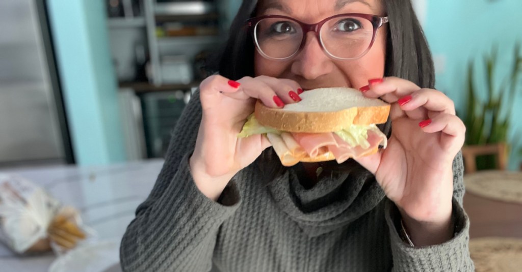 Woman eating a keto sandwich made with Hero Classic White Bread