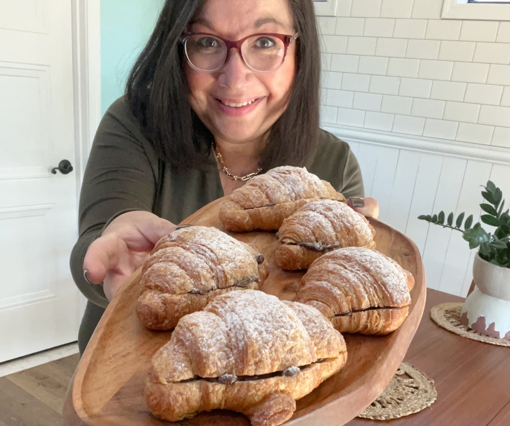 holding a platter of keto hero croissants stuffed with chocolate chips