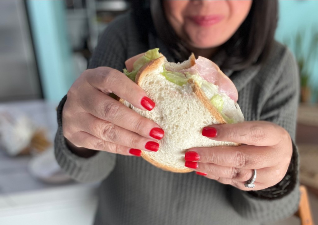 woman holding a keto sandwich made on hero classic white bread with olive oil