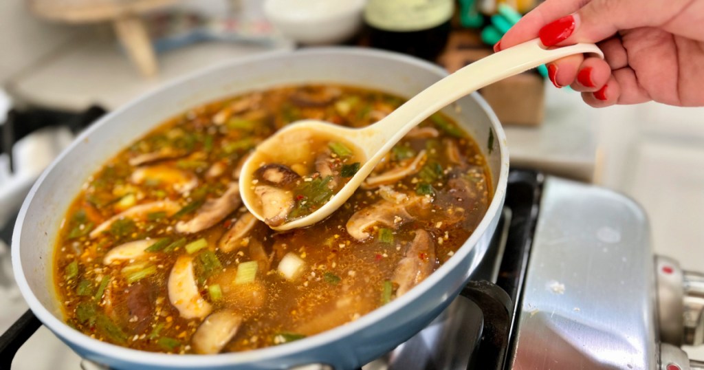 a ladle with hot and sour soup