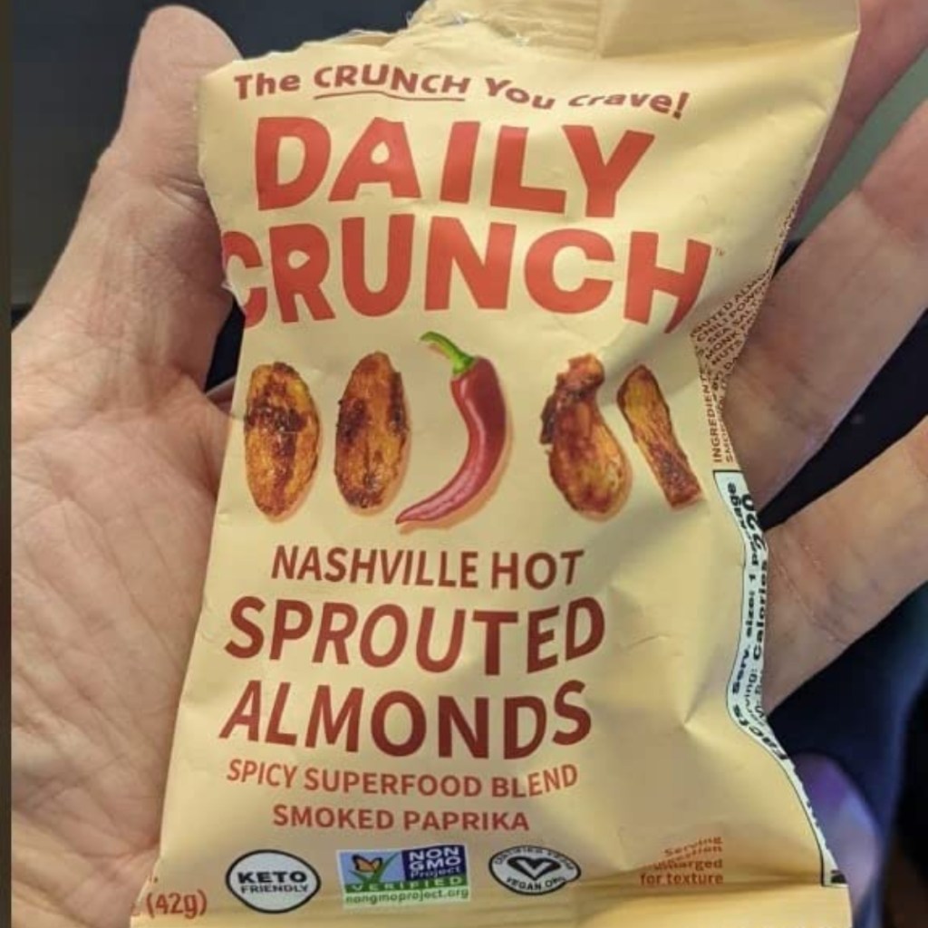holding an open bag of sprouted almonds