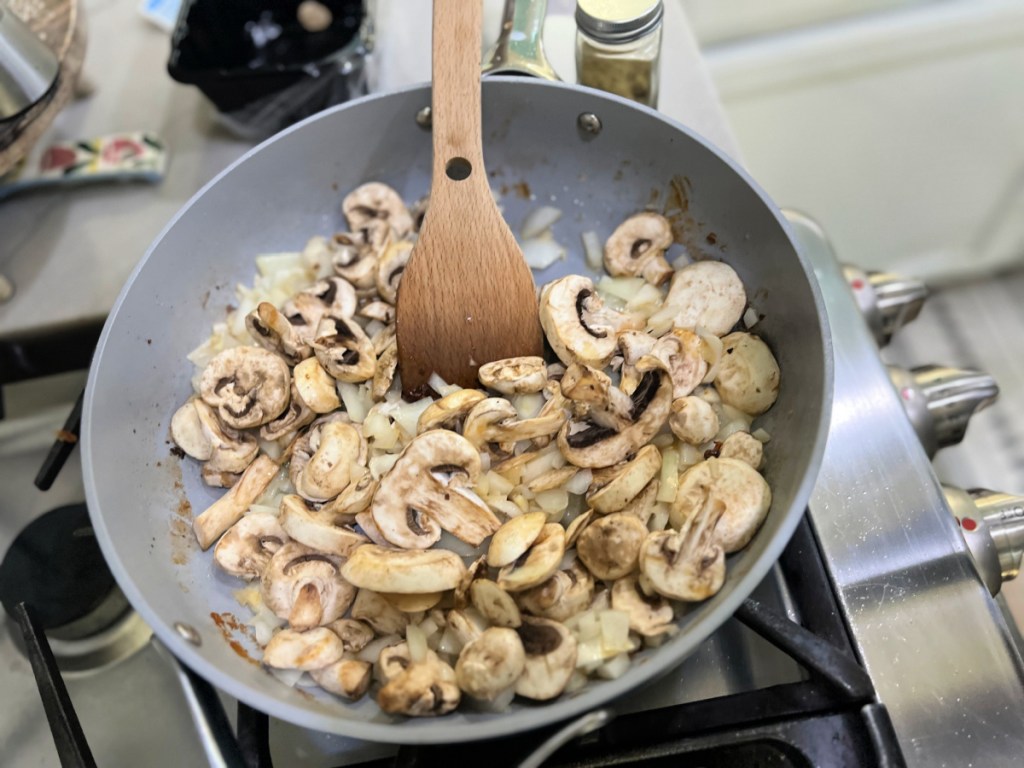 mushrooms and onion in a frying pan