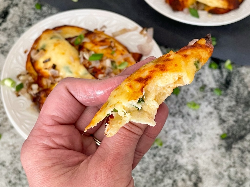 holding a keto pierogi with a bite out of it 