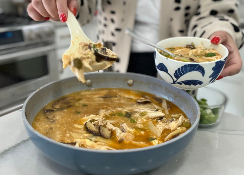 keto hot and sour soup with chicken being dished into a bowl