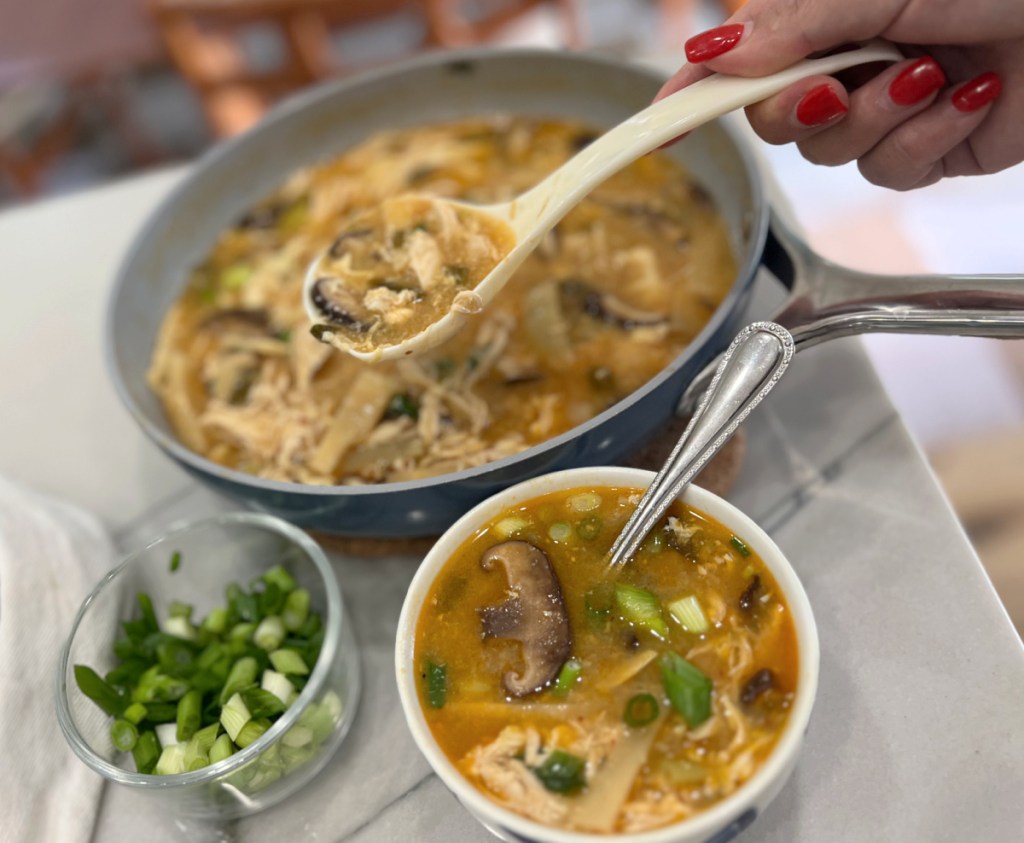 pan of keto hot and sour soup and bowl of green onions