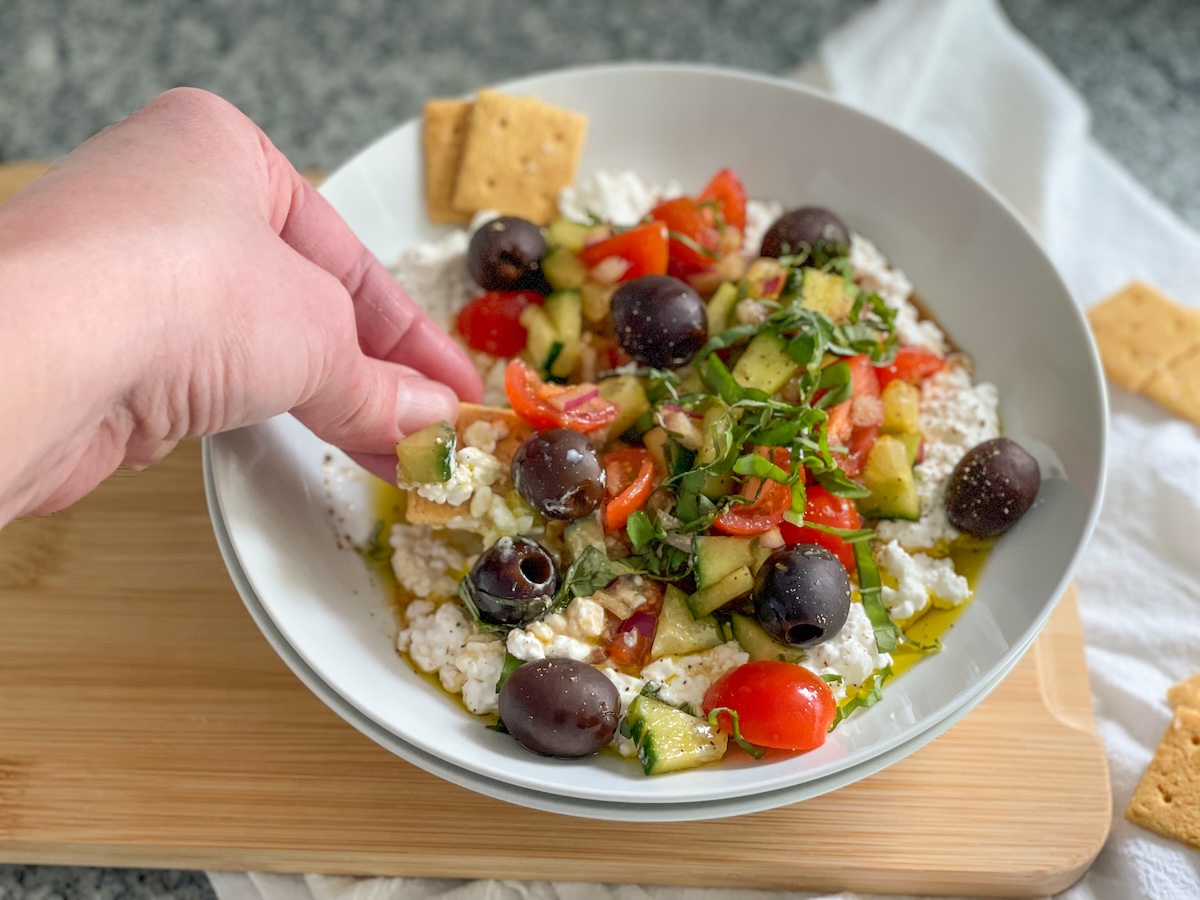 dipping a cracker in cottage cheese salad 