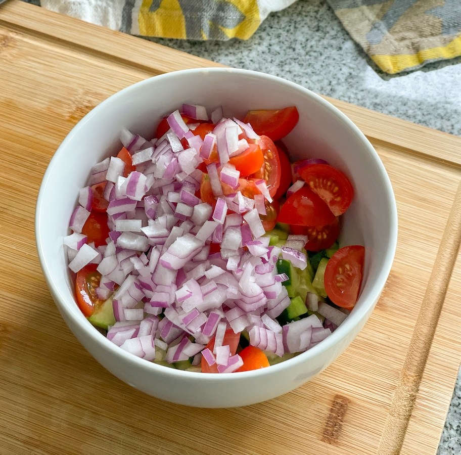 bowl with chopped tomatoes, cucumbers, and red onion