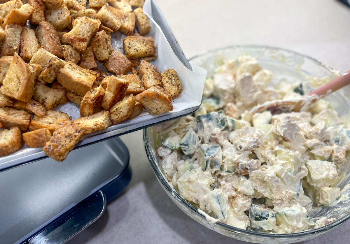keto croutons being poured into casserole mix