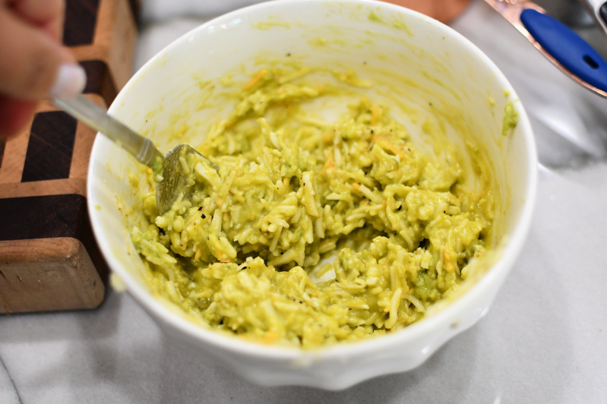 mixing avocado and shredded cheese in a bowl