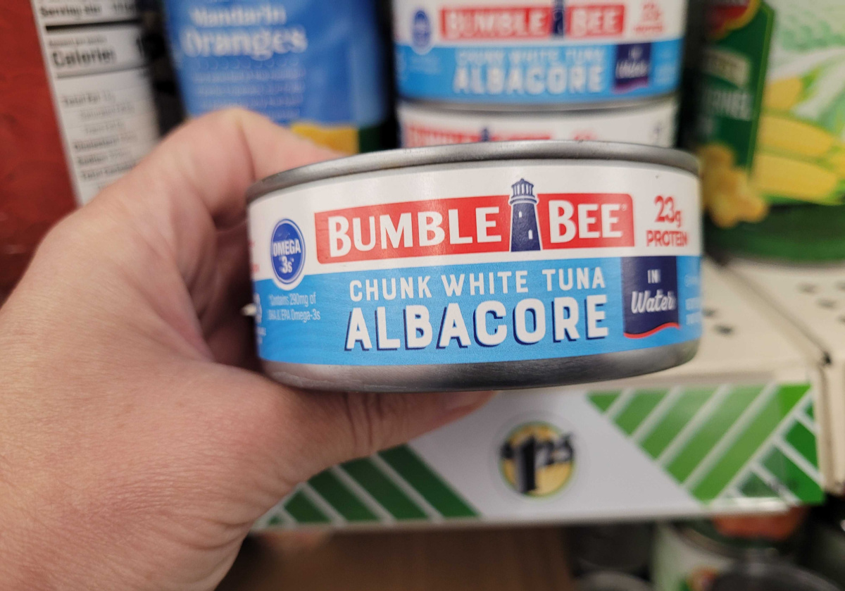 Hand holding a can of Bumblebee white albacore tuna