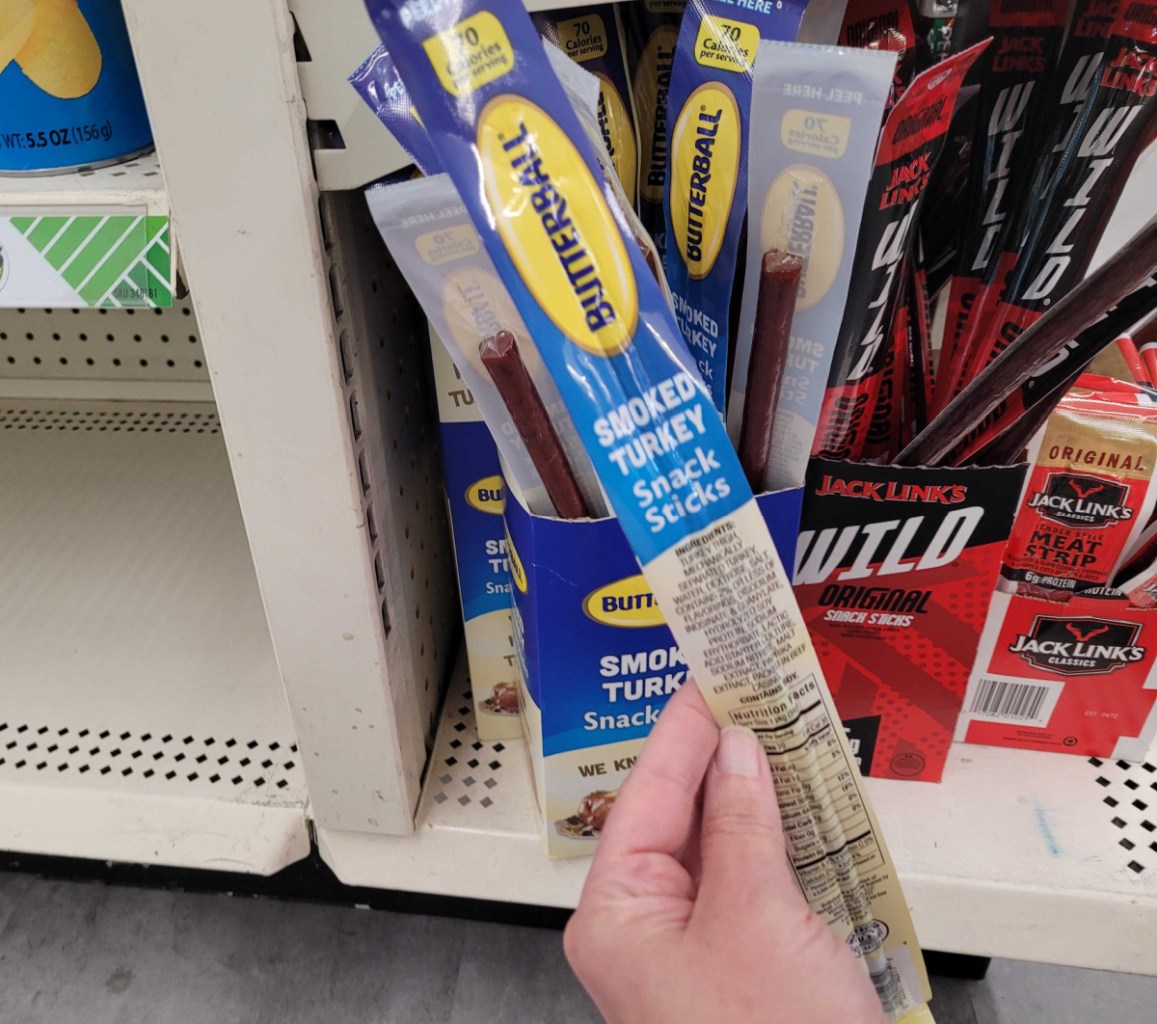 Hand holding a Butterball Smoked Turkey Stick, a low carb keto convenience store snack