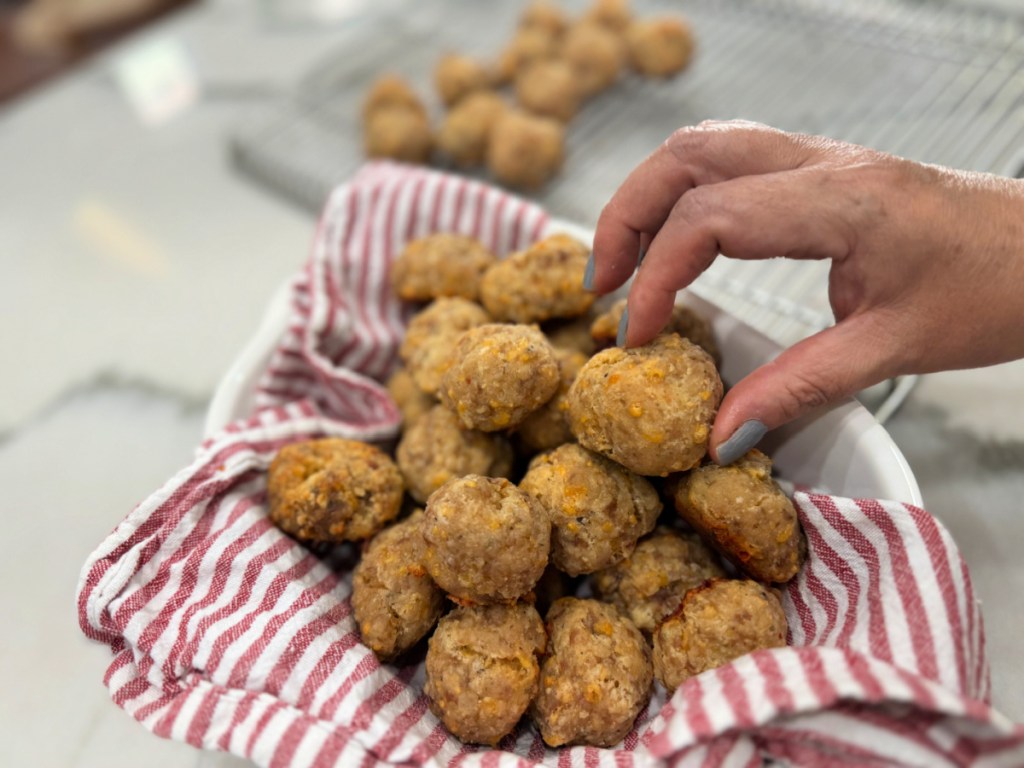 picking up sausage balls from a bowl