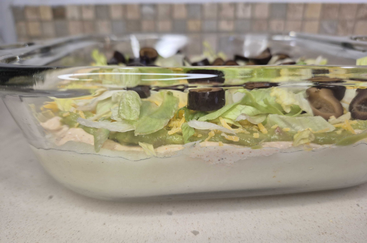keto six layer dip, or keto taco dip, shown from the side in a clear casserole dish