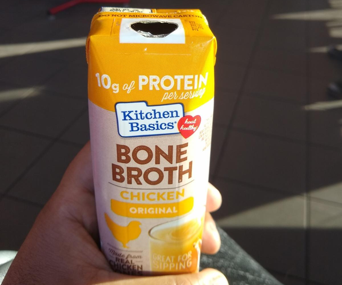 holding an open carton of bone broth
