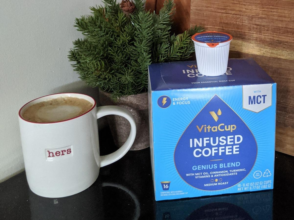 mug of coffee next to blue box of coffee pods