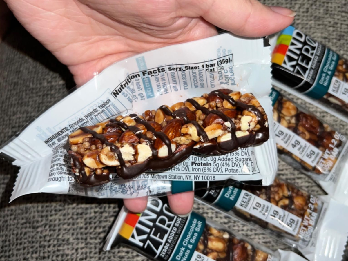 holding an open granola bar package